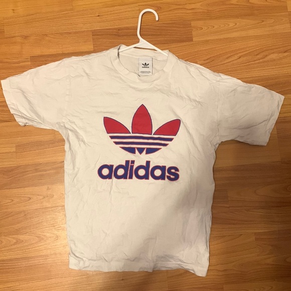 A white adidas shirt with the adidas logo and name in blue and red. - Picture 1 of 2